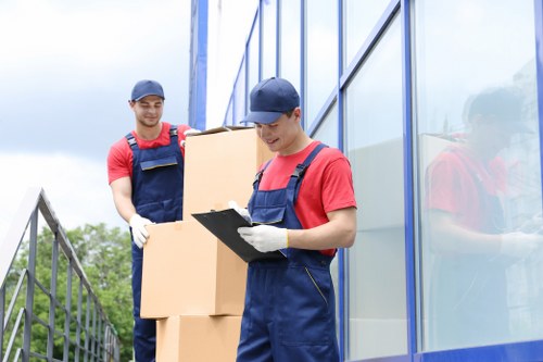 Office movers carefully handling office furniture during a commercial move in Manandvan Norbury